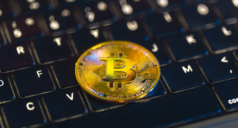 Bitcoin coin on keyboard with nice background. Crypto money concept. الفرق بين البيتكوين والعملات الرقمية الأخرى
